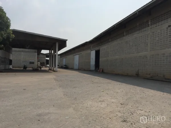 货栈 出租在Mueang Pathum Thani, Pathum Thani - 仓库区通道，雨棚连廊与多扇装卸门，卡车转弯与停靠空间充足。
