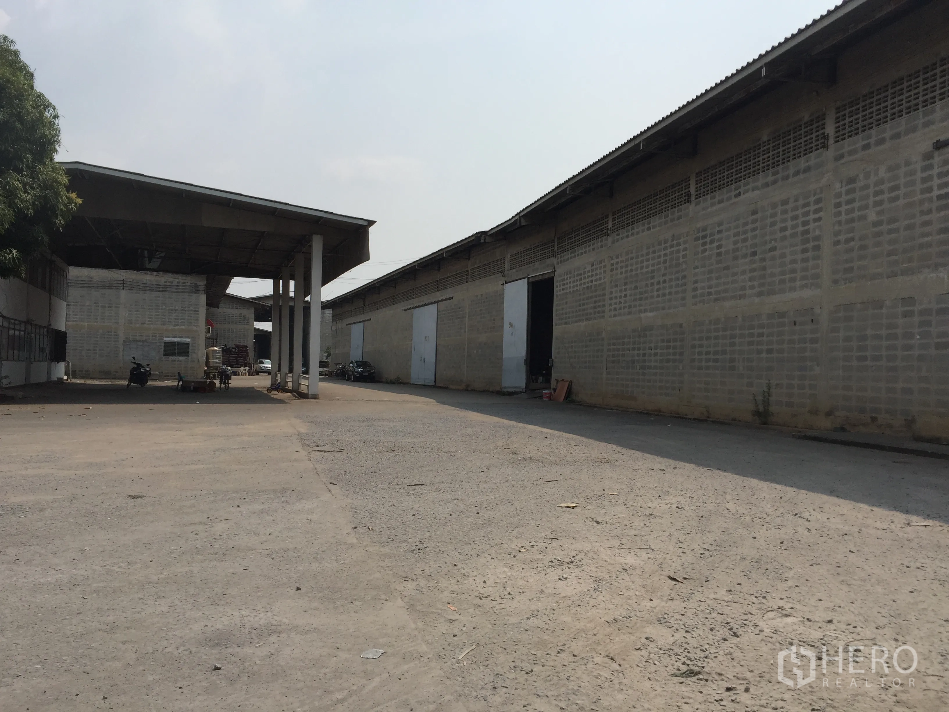 货栈 出租在Mueang Pathum Thani, Pathum Thani - 仓库区通道，雨棚连廊与多扇装卸门，卡车转弯与停靠空间充足。