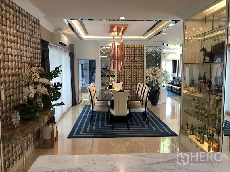 Detached House for rent or sale in Saphan Sung, Bangkok - Formal dining area with display shelves, copper pendant lights, and floor-to-ceiling windows.