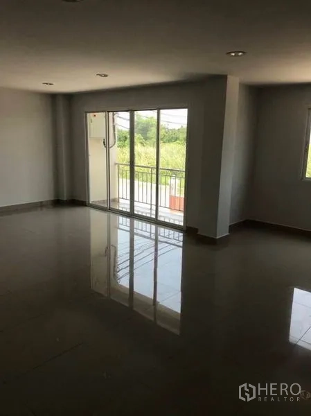 Factory for rent or sale in Mueang Samut Sakhon, Samut Sakhon - Spacious office area with sliding glass door opening to a small balcony.