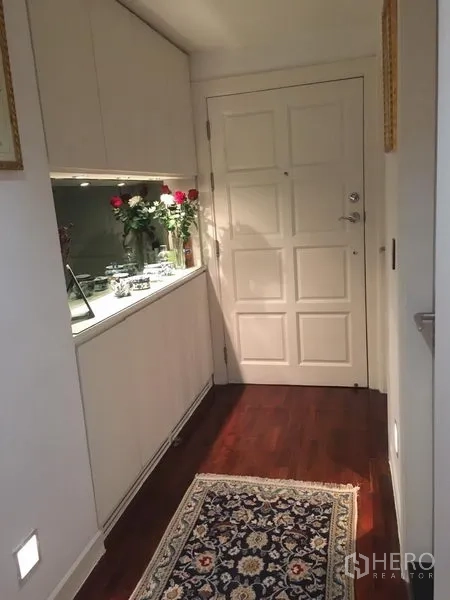 คอนโด ให้เช่า - โถงทางเข้าพื้นไม้เข้ม ประตูบานทึบสีขาว พร้อมตู้บิลต์อินและแจกันดอกไม้