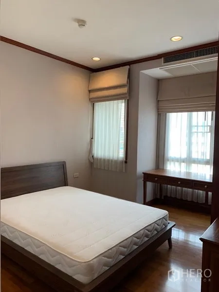 公寓 出租在Khlong Toei, Bangkok - 温馨卧室，木质床架，窗边书桌与百叶帘。