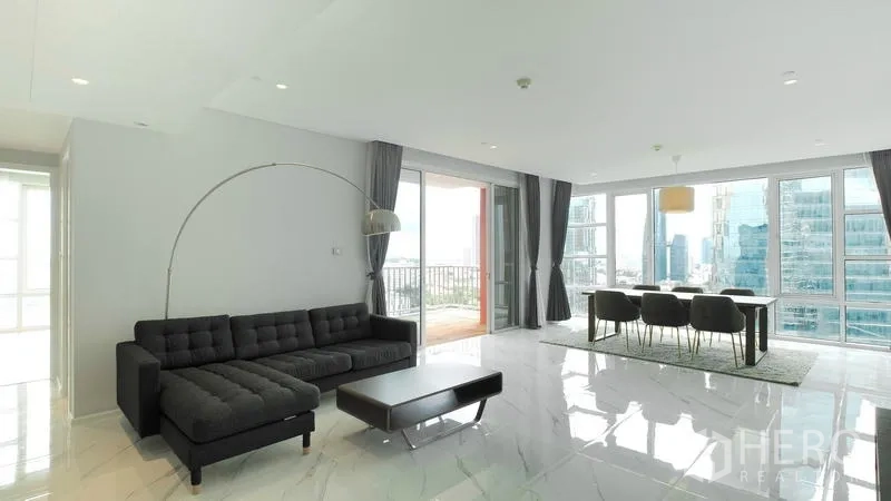 คอนโด ขาย - พื้นที่นั่งเล่นรับประทานอาหารแบบโอเพ่น พื้นแกรนิตโต้เงา และโซฟาเข้ามุมสีเทา