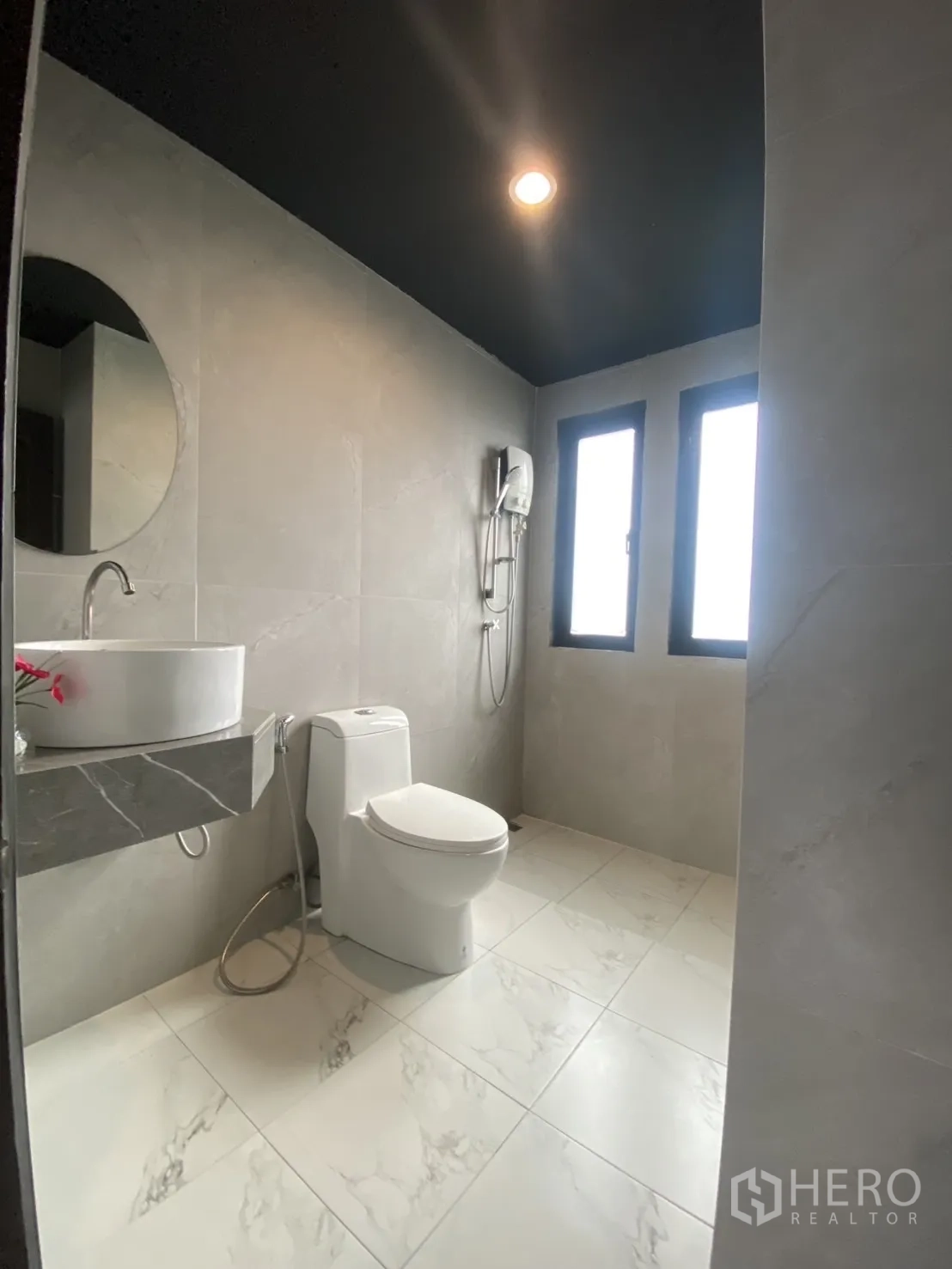 Townhouse for rent in Bang Kapi, Bangkok - Modern bathroom with round mirror, walk-in shower and two tall windows.