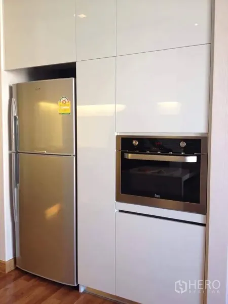 公寓 出售在Huai Khwang, Bangkok - 近景：高冰箱与嵌入式烤箱，亮面橱柜收纳。