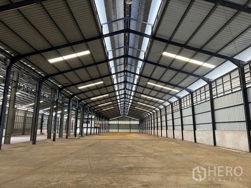 Warehouse for rent in Phra Samut Chedi, Samut Prakan - High-clear steel-frame warehouse interior with skylights and open floor.