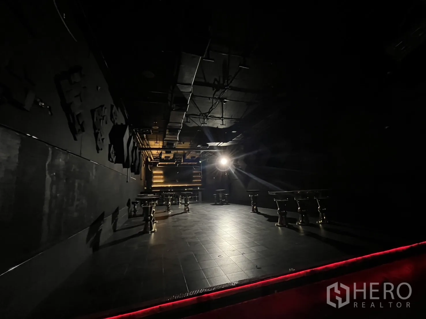 零售空间 出租 - 宽敞的黑色地砖大厅，聚光灯与工业风天花。