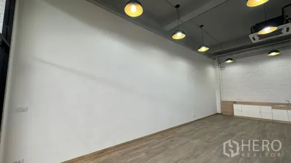 零售空间 出租 - 长展示墙、吊灯及宽敞的木纹地面销售区。