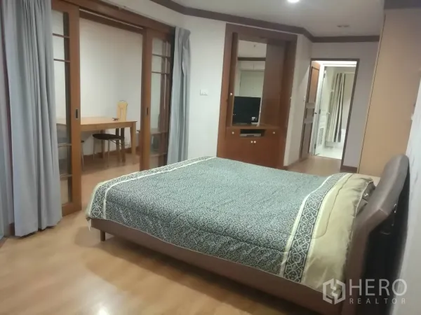 คอนโด ให้เช่าในKhlong Toei, Bangkok - ห้องนอนกว้าง เตียงคู่ ตู้บิลท์อิน และประตูกระจกบานเลื่อนไปยังมุมทำงาน