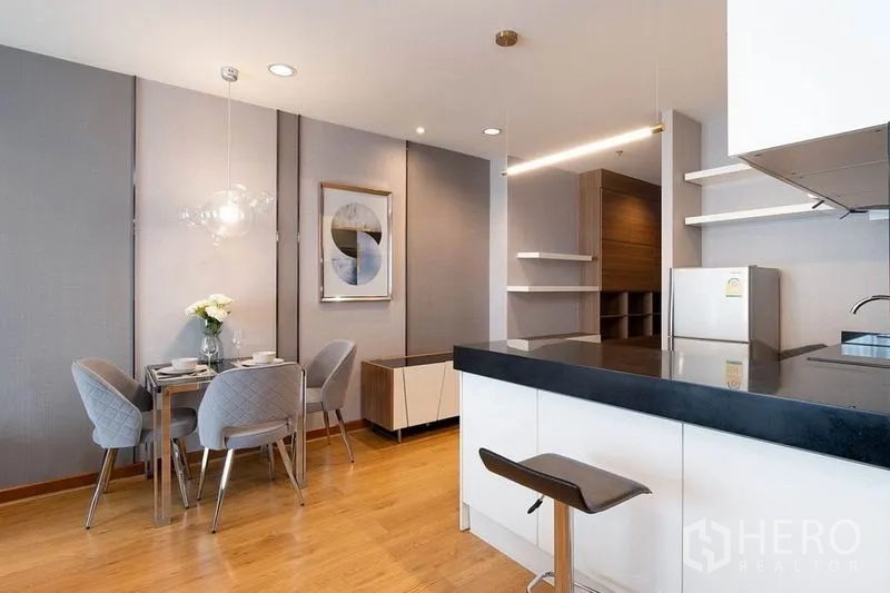 คอนโด ให้เช่าในPhaya Thai, Bangkok - ครัวเปิดเคาน์เตอร์สีดำเชื่อมพื้นที่รับประทานอาหารสำหรับสี่ที่นั่ง