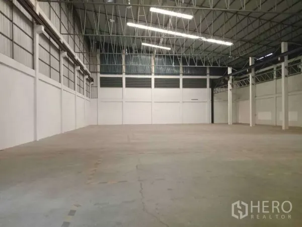 工厂 出租在Mueang Samut Prakan, Samut Prakan - 大面积制造空间，混凝土地面，明亮灯带照明与规则柱网布局。