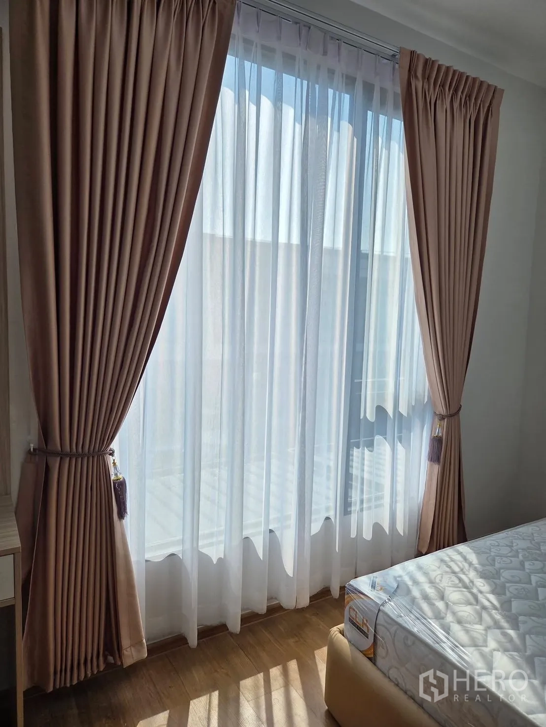 Townhouse for rent in Bang Phli, Samut Prakan - Bedroom corner with floor-to-ceiling curtains and sheer drapes allowing natural light.