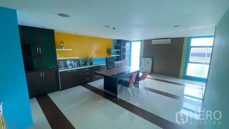 Office Space for sale in Bang Kapi, Bangkok - Private office with bright accent walls, built-in storage and a workstation.