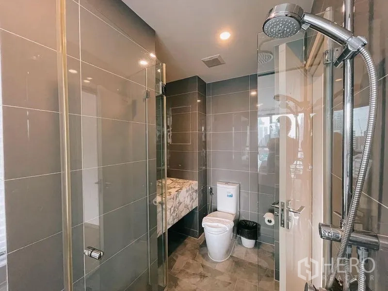 คอนโด ให้เช่าในRatchathewi, Bangkok - ห้องน้ำโมเดิร์นพร้อมตู้กระจกอาบน้ำ โถสุขภัณฑ์ และเคาน์เตอร์ลายหินอ่อน