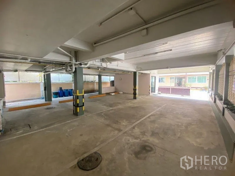 Home Office for rent in Don Mueang, Bangkok - Covered ground-floor parking area with marked bays and pillars.