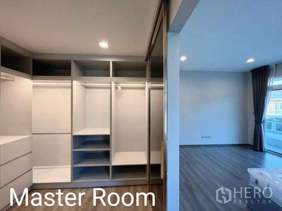 Detached House for rent in Samut Prakan - Master bedroom walk-in closet featuring built-in wardrobes and sliding glass doors.