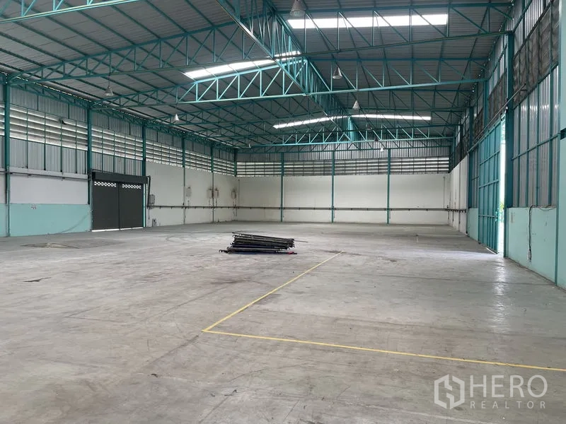 Warehouse for rent in Lat Lum Kaeo, Pathum Thani - Warehouse hall featuring large roller shutter doors, bright lighting and marked floor zones for storage or production.