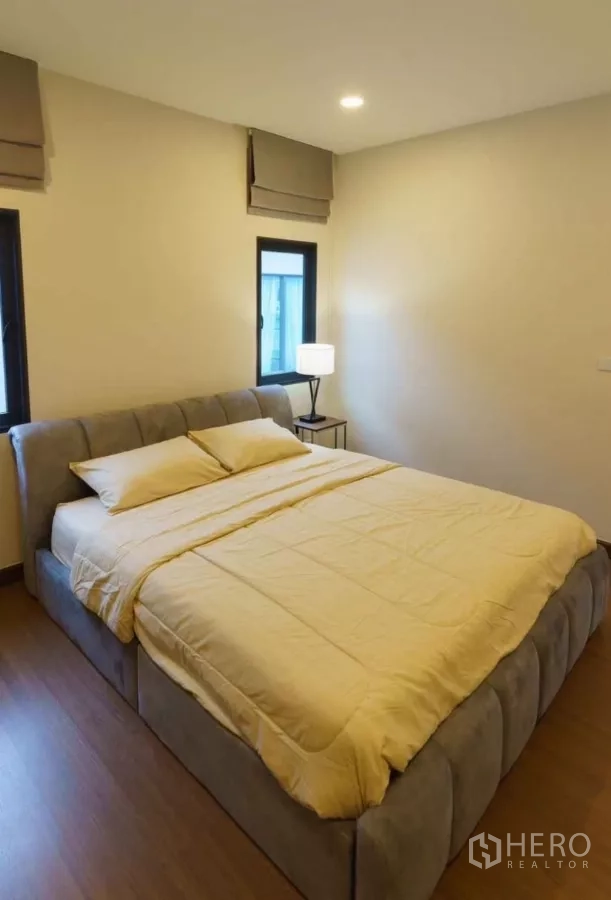 Detached House for rent or sale in Bang Phli, Samut Prakan - Cozy bedroom with upholstered bed frame and warm bedding.