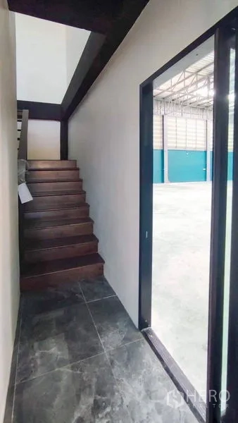 Factory for sale in Bang Pakong, Chachoengsao - Staircase to mezzanine office beside sliding door to warehouse floor
