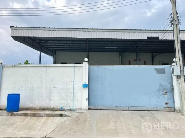 โรงงาน ให้เช่าในSamut Prakan - ทางเข้าโรงงาน ประตูเหล็กบานเลื่อน กำแพงสูง และหลังคาลานขนถ่าย