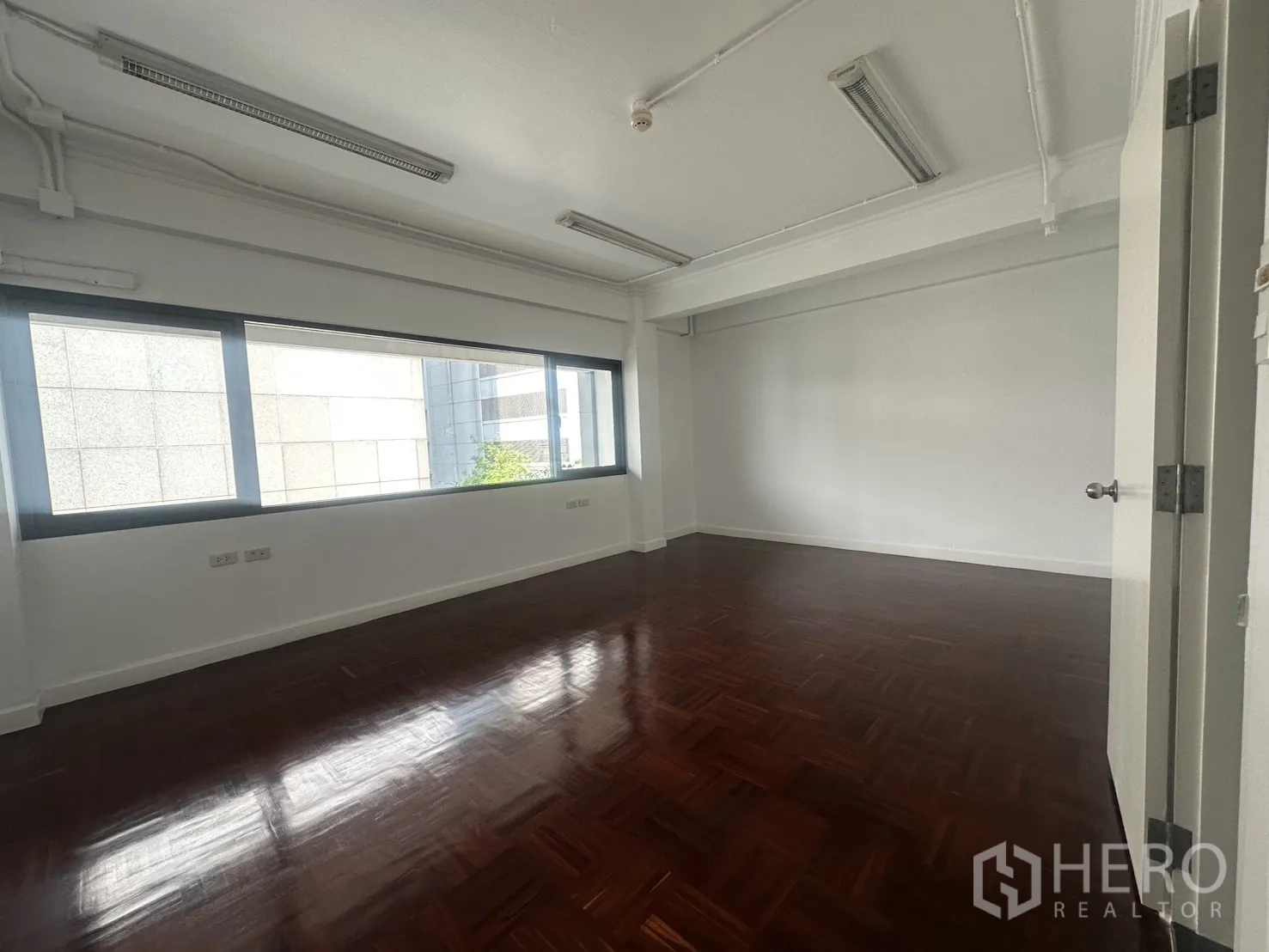 办公室 for rent in Watthana, Bangkok - 独立办公室，横向大窗与深色木地板。