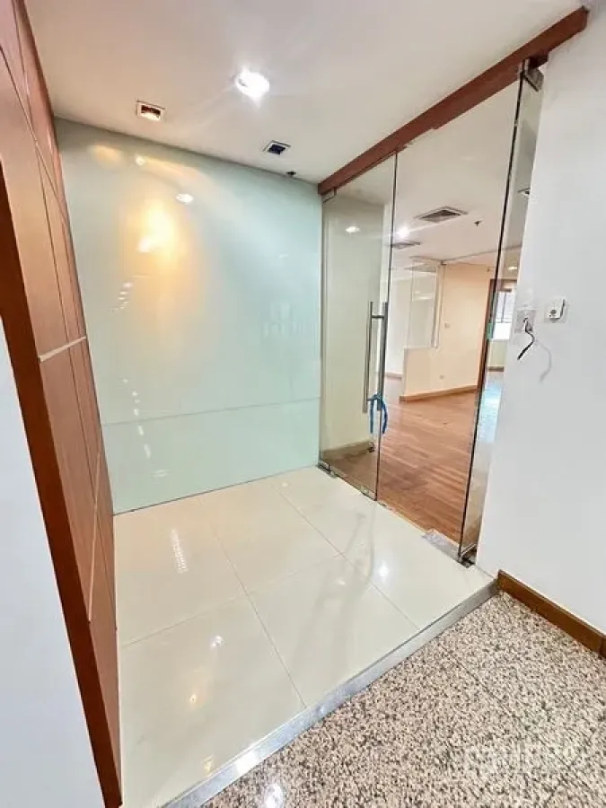 Office Space for rent - Secure glass-door entry with frosted wall and polished tile lobby.