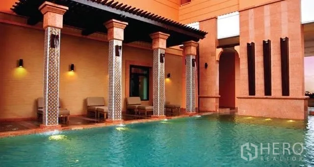 คอนโด ให้เช่าในKhlong Toei, Bangkok - สระว่ายน้ำกลางแจ้ง เสาแต่งลาย เก้าอี้พักผ่อน และผนังโทนอิฐส้ม