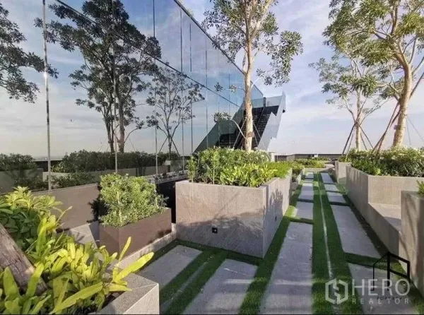 Condominium for rent in Sathon, Bangkok - Sky garden walkway with planters and a mirrored glass facade.