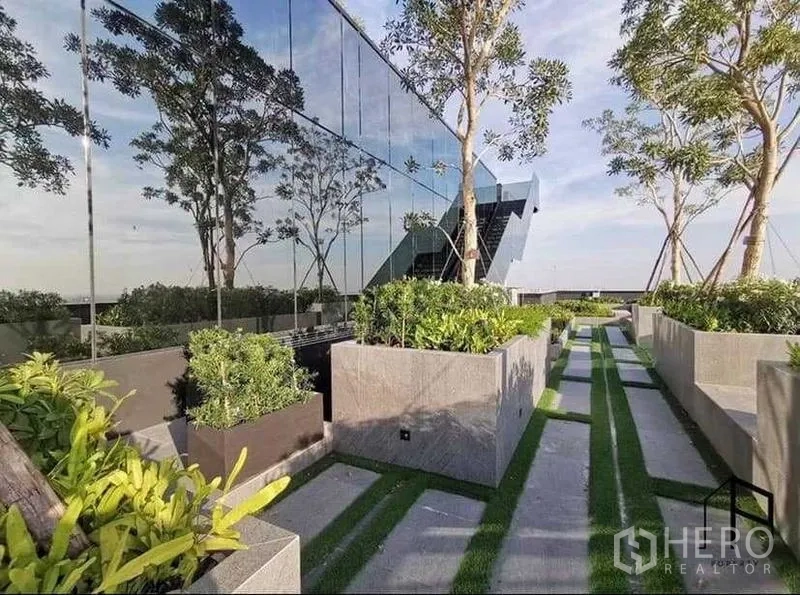 Condominium for rent in Sathon, Bangkok - Sky garden walkway with planters and a mirrored glass facade.