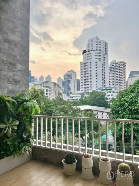 อาคารพาณิชย์ ให้เช่าในWatthana, Bangkok - ระเบียงที่วางต้นไม้กระถาง กับทิวตึกยามเย็นเหนือเรือนยอดไม้