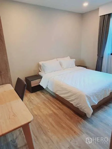 Condominium for rent in Sathon, Bangkok - Cozy bedroom with double bed, work desk and window with blackout curtains.