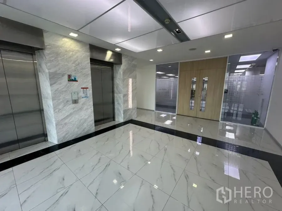 Office Space for rent - Elevator lobby with glossy marble floors and twin lifts in a modern office.