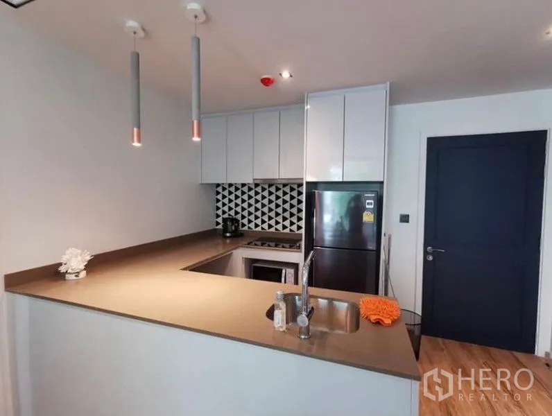 คอนโด ให้เช่าในSathon, Bangkok - ครัวยูเชป ตู้สีขาว ฉากหลังลายเรขาคณิต เตาและอ่างล้างจานบิวท์อิน