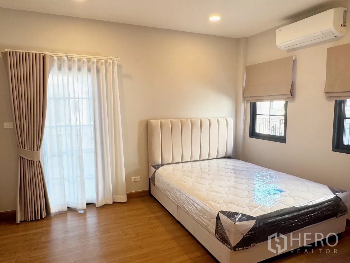 Detached House for rent or sale in Bang Phli, Samut Prakan - Bright secondary bedroom with bed, curtains and air conditioner.