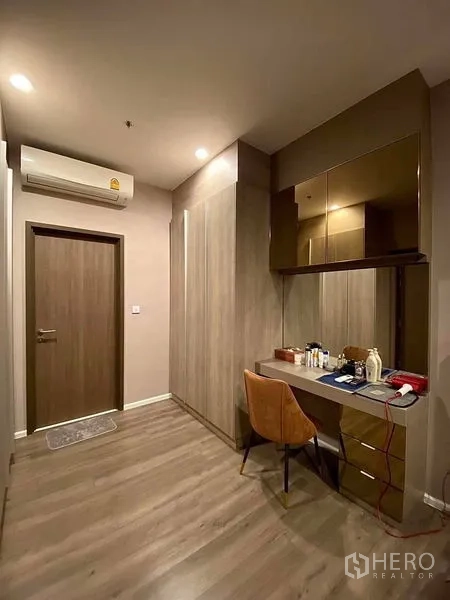 Condominium for rent in Phra Khanong, Bangkok - Bedroom dressing area with vanity, wardrobe and warm wood floors.
