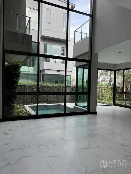 บ้าน ขายในBang Kruai, Nonthaburi - หน้าต่างสูงจรดเพดานเปิดมุมมองสู่สวนและสระจุ่ม