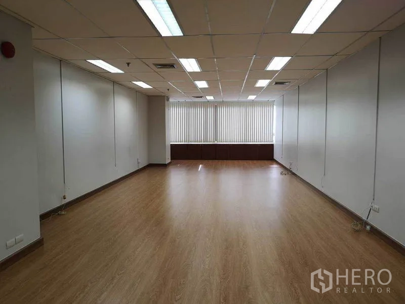 办公空间 出租在Watthana, Bangkok - 开放式办公室，大窗配垂直百叶，木地板、白色墙面与顶灯。