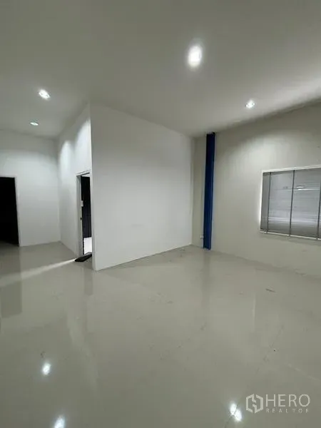 Warehouse for rent in Krathum Baen, Samut Sakhon - Clean ground-floor office space with white walls, tiled flooring and a side window.