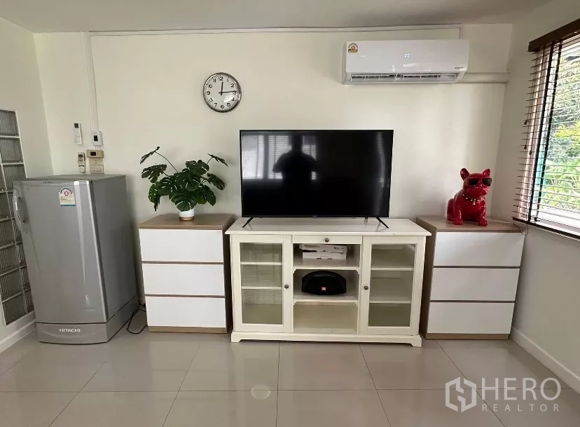 บ้าน ให้เช่า - ผนังทีวีพร้อมตู้คอนโซล ตู้เย็น และแอร์ในห้องนั่งเล่นสมัยใหม่.