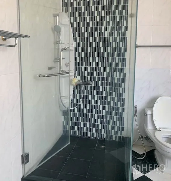 Detached House for rent in Din Daeng, Bangkok - Bathroom with glass-enclosed shower and mosaic tile accent wall.