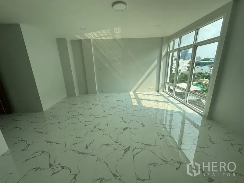 Home Office for rent or sale - Sunlit upper-floor room with full-height corner windows and city views over Phra Khanong.