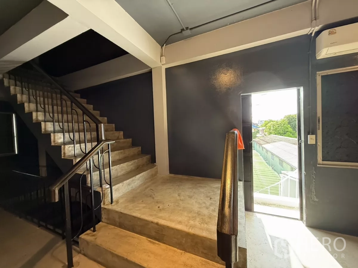 Office Space for rent in Wang Thonglang, Bangkok - Concrete stairwell with metal handrail leading to an exterior door.