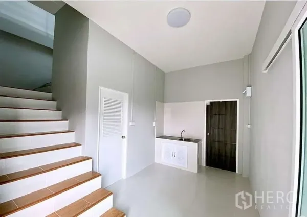 Warehouse for sale in Pathum Thani - Ground-floor pantry and service area beside the staircase with sink and storage.