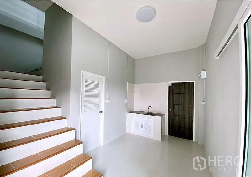 Warehouse for sale in Pathum Thani - Ground-floor pantry and service area beside the staircase with sink and storage.