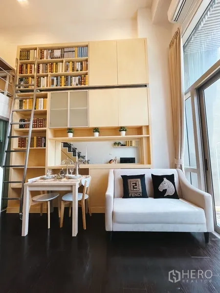 公寓 出租或出售在Khlong Toei, Bangkok - 窗边双人沙发与餐桌，定制柜体与滑门置物。