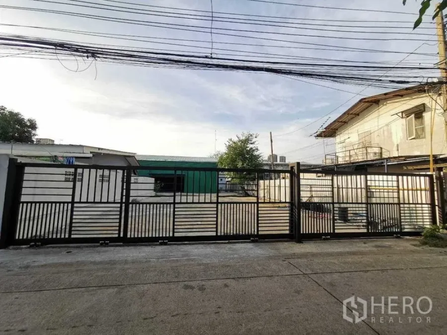 Warehouse for rent in Bang Na, Bangkok - Street view of secure sliding gate enclosing the property