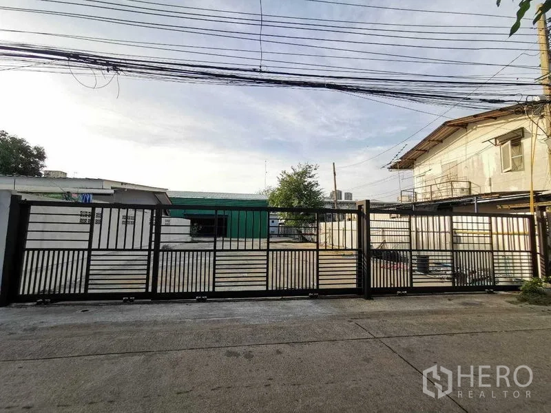 Warehouse for rent in Bang Na, Bangkok - Street view of secure sliding gate enclosing the property