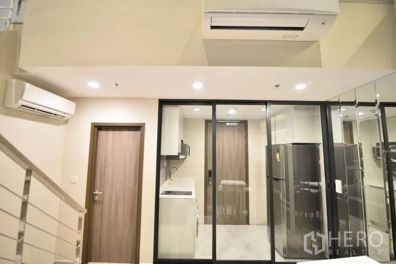 公寓 出租在Huai Khwang, Bangkok - 滑动玻璃后的厨房区，配冰箱、橱柜与空调