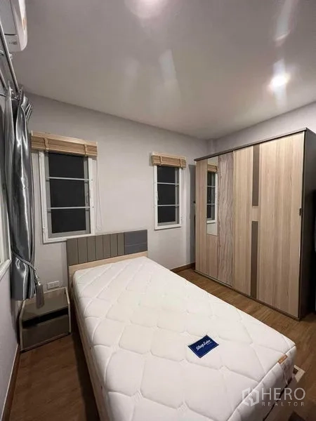 บ้าน ให้เช่าหรือขายในLat Krabang, Bangkok - ห้องนอนรองมีเตียงเดี่ยว ตู้เสื้อผ้า และหน้าต่างคู่