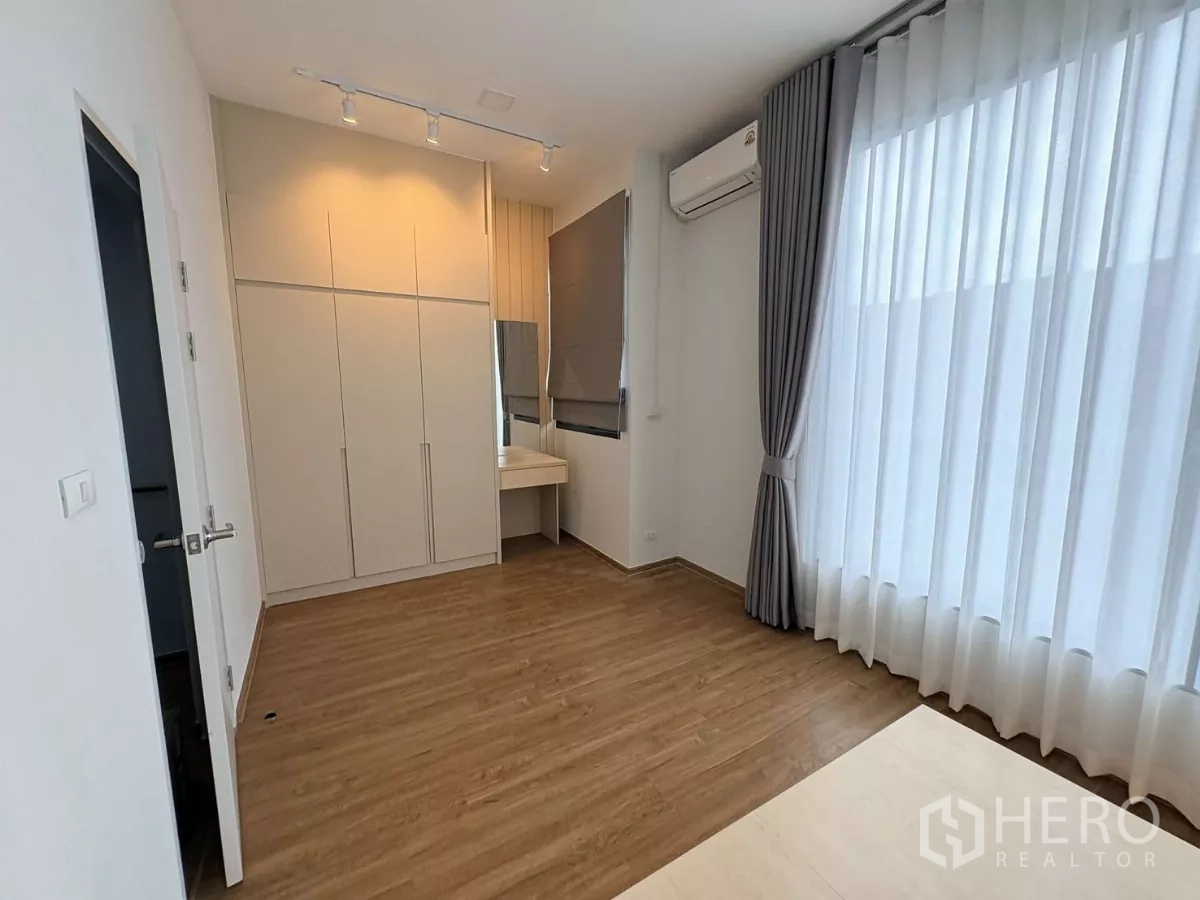 Townhouse for rent in Bang Phli, Samut Prakan - Bright master bedroom with built-in wardrobe, dressing corner and full-height curtains.